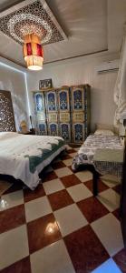 马拉喀什DAR SARSAR airport的一间卧室设有两张床,铺有一个 ⁇ 板地板