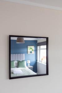 格拉斯哥Winton House的镜子反射着卧室,卧室配有床和窗户