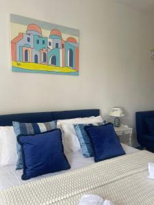 伊斯基亚海王别墅住宿加早餐旅馆的一间卧室配有一张带蓝色枕头的床和一幅画