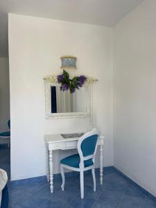 伊斯基亚海王别墅住宿加早餐旅馆的一张带蓝色椅子和镜子的白色书桌