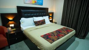 拉各斯The Lodge-Stack By Kabachi的一张位于酒店客房的床位,配有红色椅子