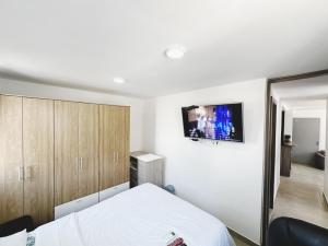 巴兰基亚Apt AA 15min CC B/Vista low cost的卧室配有一张床,墙上配有电视。