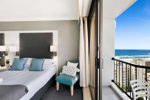 黄金海岸Sleek and Central Studio Apartment的一间卧室设有一张床和一个海景阳台