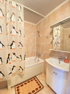 阿克托比Уютный апартамент的浴室设有用企鹅制成的淋浴帘
