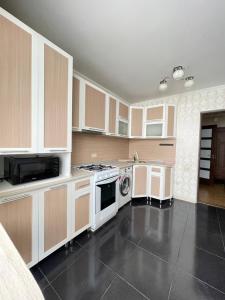 阿克托比Уютный апартамент的厨房配有白色橱柜和炉灶烤箱。