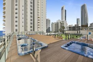 黄金海岸Ocean View Studio with Rooftop Jacuzzi的大楼屋顶上的两个热水浴池