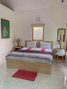 日惹Carla Garden Villa的一间卧室配有一张大床和两个红色枕头