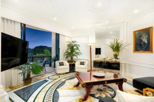 黄金海岸Imperial Hotel Gold Coast的客厅配有电视、沙发和桌子