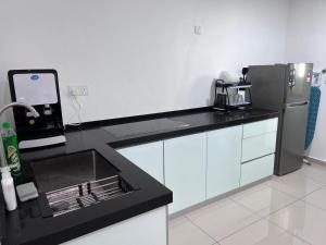 大山脚Metropol Serviced Apartment Bukit Mertajam Perda的厨房配有水槽和冰箱
