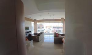 齐克拉约HERMOSO DEPARTAMENTO-DUPLEX CON VISTA DE CHICLAYO的带沙发和大窗户的客厅