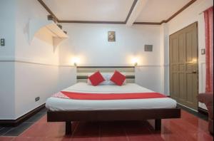 Lapu Lapu CityMax Travellers Inn的一间卧室配有一张带两个红色枕头的床