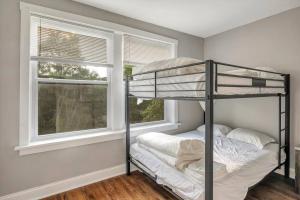 Clifton HeightsBeautiful Brand New Tower Grove Unit 1s的一间卧室配有双层床和2个窗户。