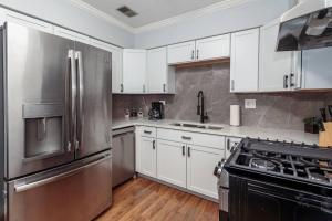 芝加哥2 MTM Fully Furnished Rental in Old Town 2f&2r的厨房配有白色橱柜和不锈钢冰箱