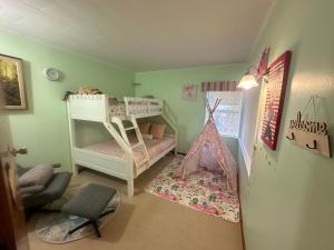 奥克兰Lucky house的儿童卧室配有双层床和椅子