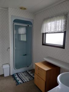 旺阿雷Denby Golf House Tikipunga的一间带玻璃淋浴和水槽的浴室
