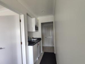 新普利茅斯Panoramic vista on burns的厨房配有白色橱柜和黑色台面