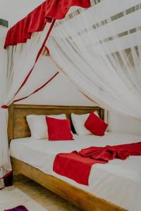 马特勒Lihini Villa ii的一间卧室配有红色和白色枕头的床