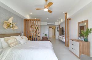 圣多明各Juan Dolió Service Vip的卧室配有白色的床和吊扇