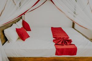 马特勒Lihini Villa ii的一张带红色枕头的床和红色的盒子