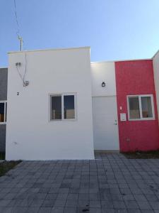 圣安娜Mini casa Ecoterra Santa Ana的白色和红色的建筑,设有两扇窗户