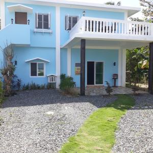 San IsidroWhitesands Beach Resort的带阳台的蓝色房屋和碎石院