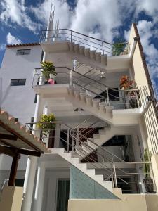 阿亚库乔PERLASCHALLAY的一座白色的建筑,上面有楼梯和盆栽植物