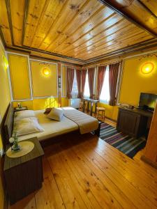 科普里夫什迪察Guest rooms Colorit的一间卧室设有一张大床和木制天花板