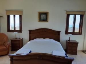 帕福斯Nayia Paradise Villa! Best Villa in Cyprus的一间卧室配有一张床、一把椅子和窗户。