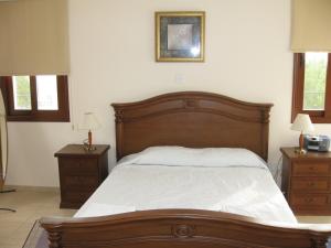 帕福斯Nayia Paradise Villa! Best Villa in Cyprus的一间卧室设有一张大木床和两个床头柜。