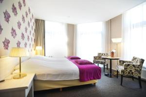 德文格洛维瑟林酒店的一间卧室配有一张大床和紫色毯子