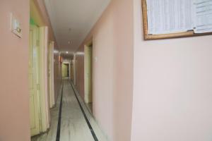 那格浦尔SPOT ON Shraddha Hotel的走廊上设有白色的墙壁和墙上的照片