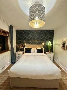 都柏林Blush Jungle的卧室配有一张白色大床和吊灯。