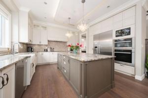 温哥华Dunbar Luxury Homestay的一个带白色橱柜和大岛的大厨房