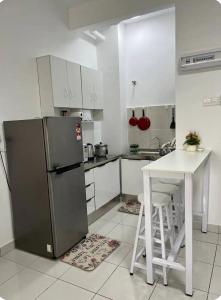 汝来Camelia Youth City Nilai Studio residence 5pax的带冰箱和桌子的厨房