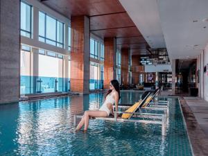 曼谷Renaissance Bangkok Ratchaprasong Hotel的坐在游泳池的水中的女人