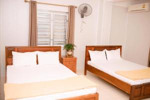 荣市Thảo Nguyên Hotel的白色墙壁客房的两张床