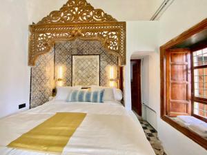 西迪·布·赛义德Suite Noor B&B Pool SidiBouSaid的一间卧室配有一张白色大床和金色床头板