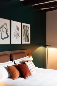 勒波诺La Maison OBONO Hôtel & Spa的卧室配有一张四幅画的墙壁床。