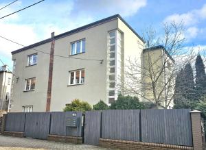 霍茹夫URBAN APARTMENTS COSY No 4 Chorzów Katowice, FREE PRIVATE PARKING的前面有栅栏的建筑