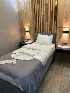 Bostaniçiworld say hotel的一间卧室配有一张带白色床单和两盏灯的床。
