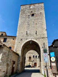 古比奥Casa Vacanze Il Borgo的一座大型砖砌建筑,设有大型石拱门