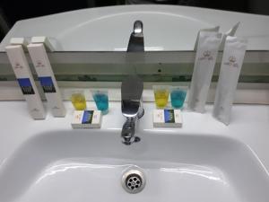 杜尚别ORIYO DUSHANBE HOTEL的浴室水槽配有玻璃杯和水龙头