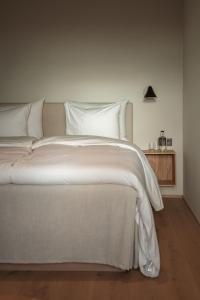 锡姆里斯港Hotel Vyn的一张白色大床,配有白色床单和枕头