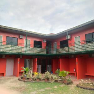 Lapu Lapu CityMax Travellers Inn的带阳台和植物的红色建筑