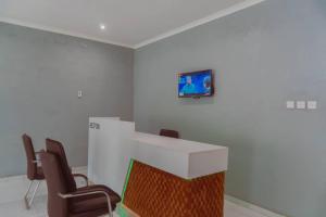 MangochiAdams lodges Ltd的一间带椅子的房间和一个墙上的电视的柜台