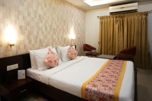 西里古里Voyage Comfort Primer Inn的酒店客房配有一张带枕头的大床