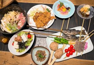 松本Asama Onsen FAN! MATSUMOTO的餐桌上摆放着食物和筷子