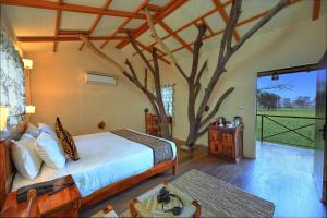 萨瓦伊马多普尔Bagh Serai - Rustic Cottage with Private Pool的一间卧室,卧室里有一棵树,