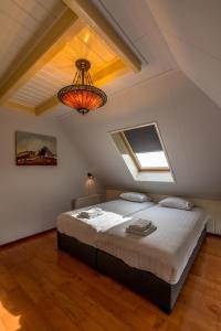 OosterendBoerderijwoning De Florijn的阁楼上的卧室配有一张大床