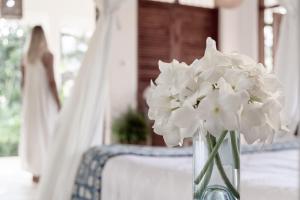 基利菲Tarangau Retreat的花瓶,花瓶上满是白色的花朵,坐在桌子上